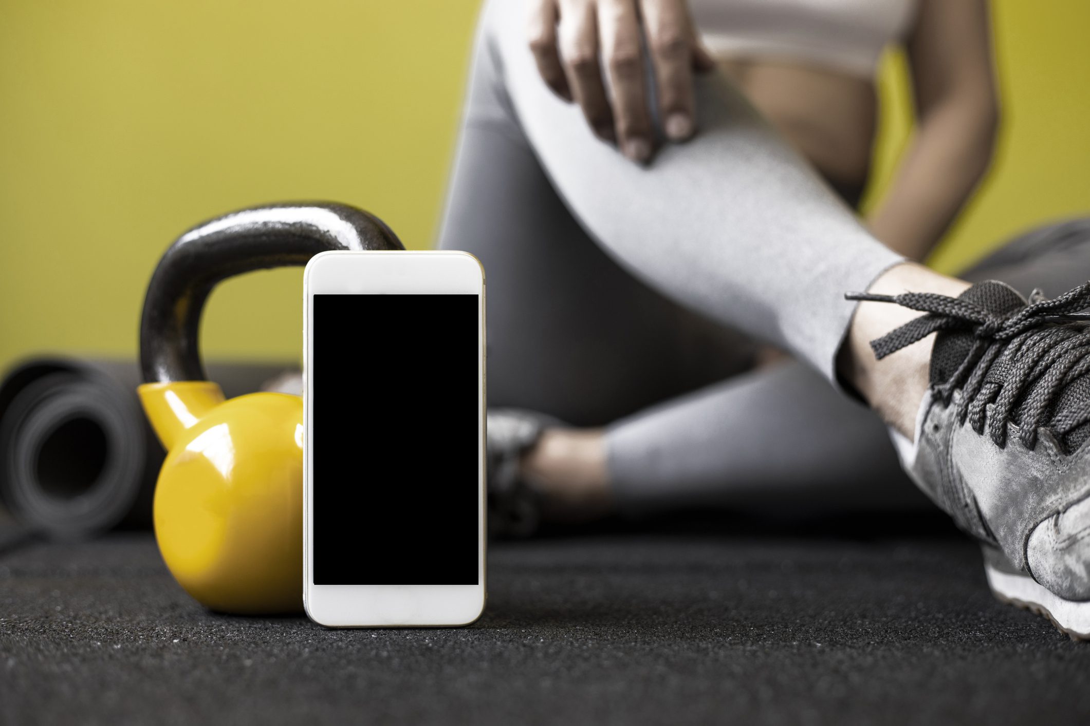 Sporty woman with smartphone Bridgeport In-Home Fitness